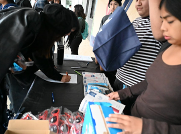 Students at a sign-in and outreach table