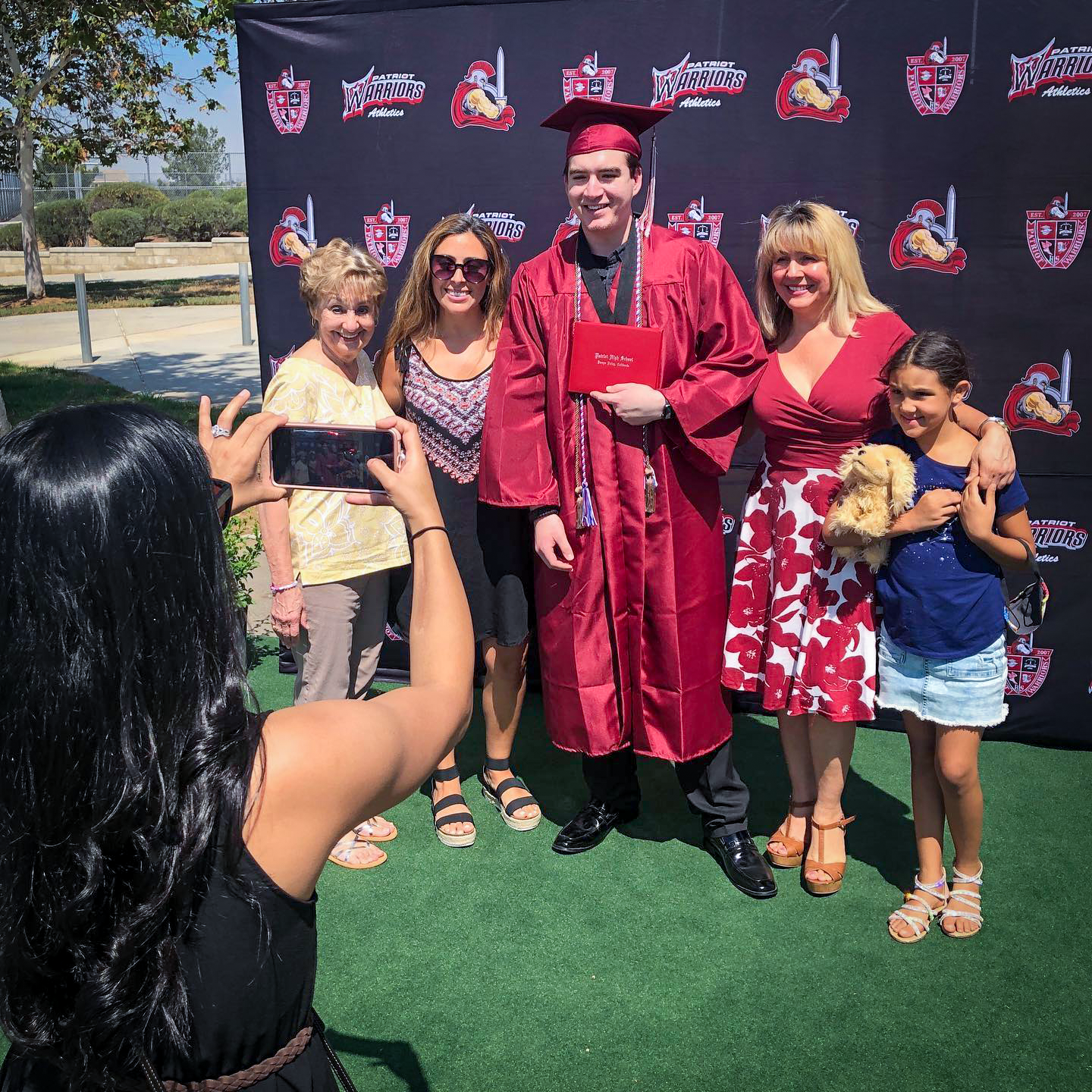 Patriot graduate and family pose for graduation photo