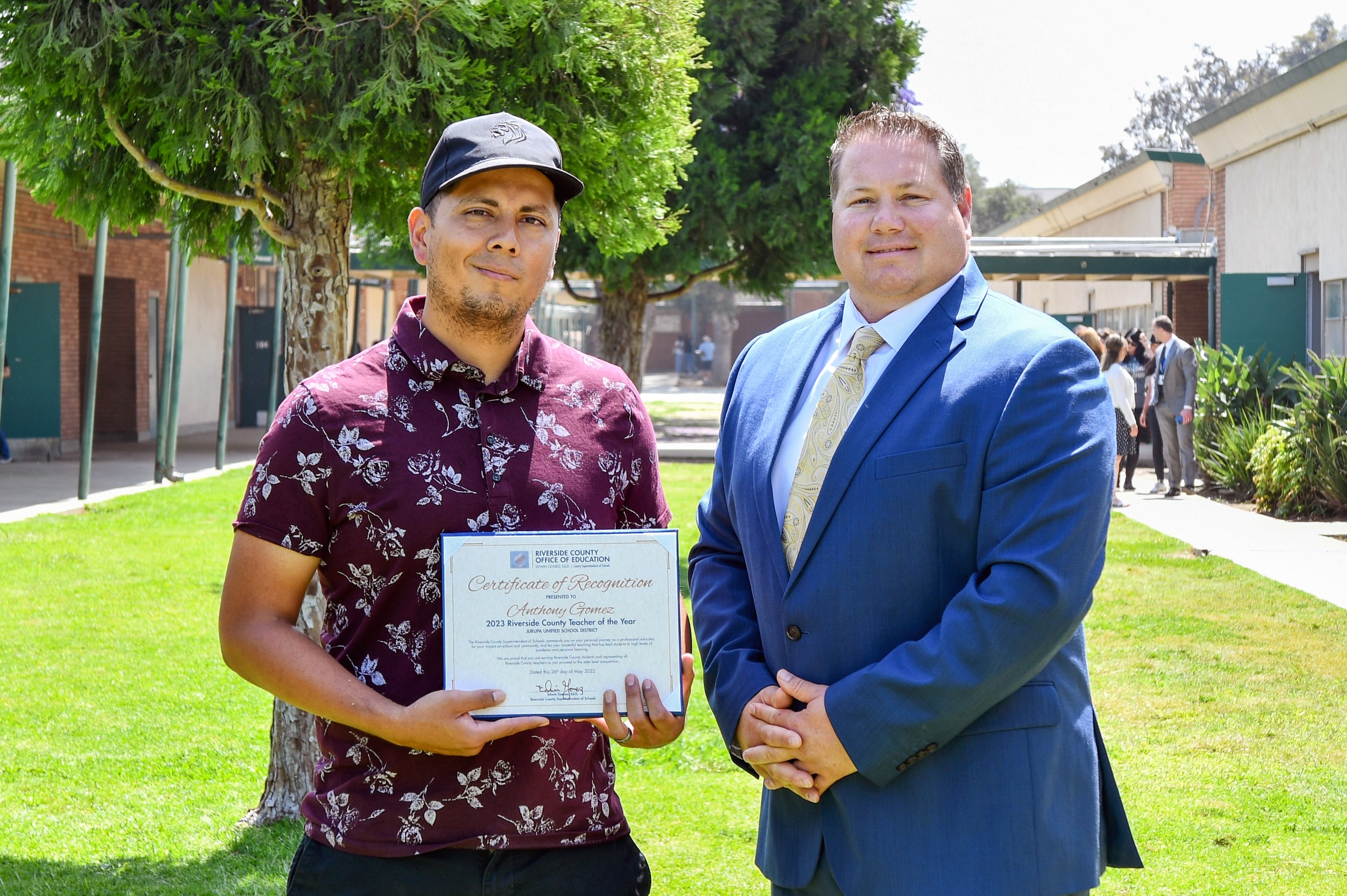 Anthony Gomez holding his certificate beside Dr. Hansen
