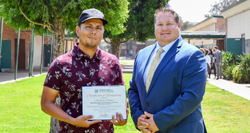 Anthony Gomez holding his certificate beside Dr. Hansen