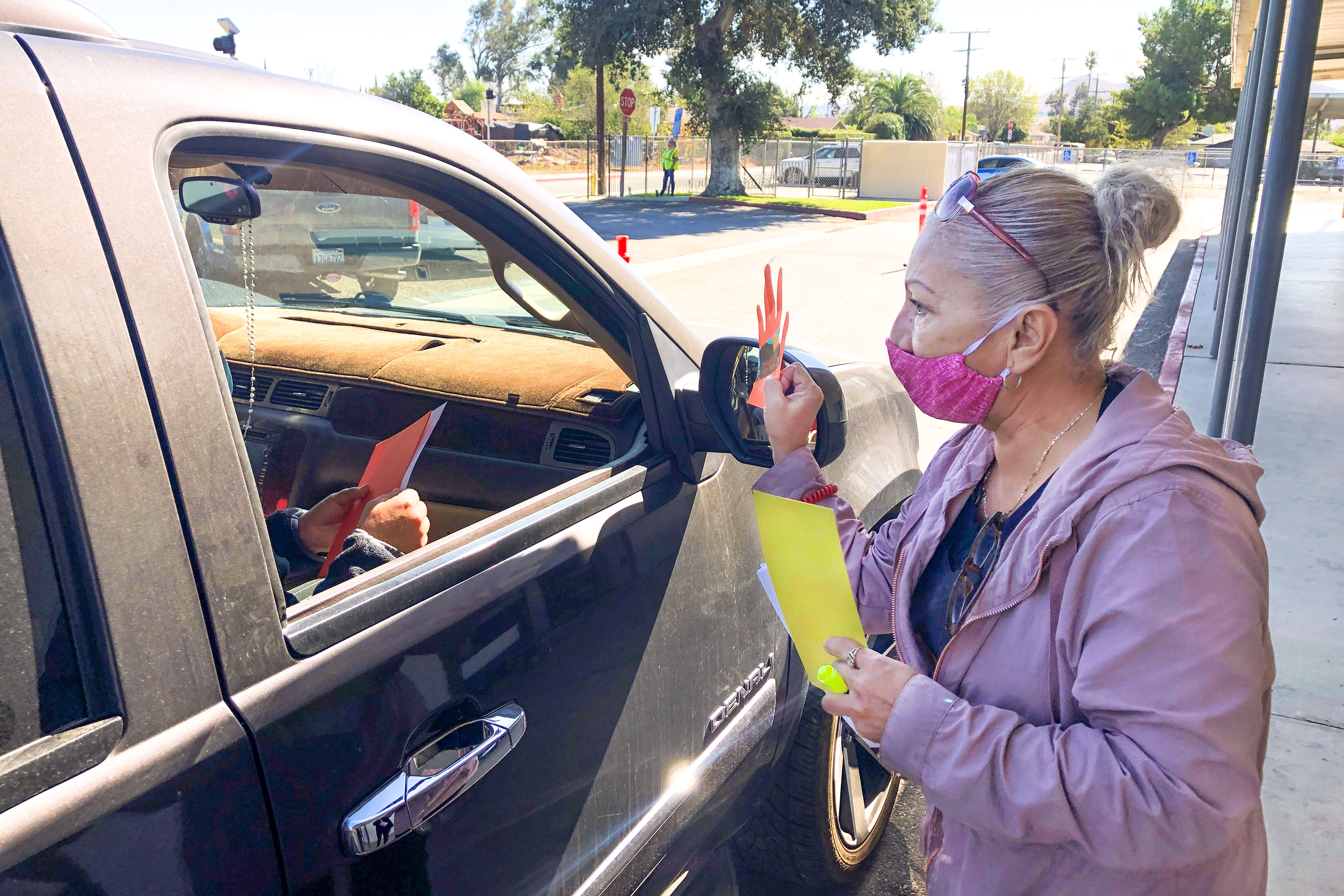 Troth Street Staff member hands out paper