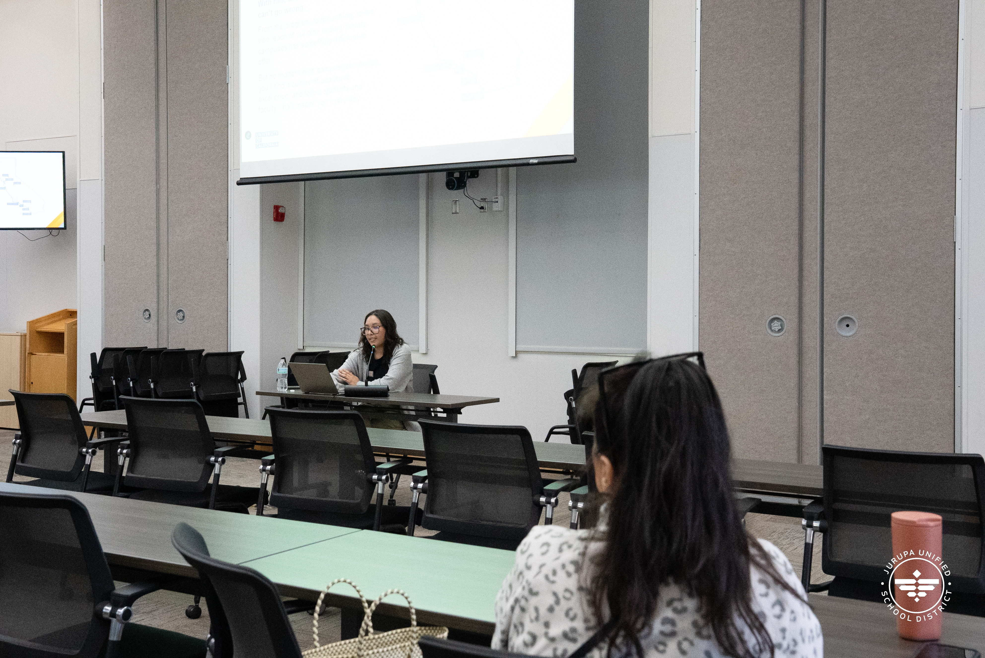 A parent listens attentively as Maria Flores presents
