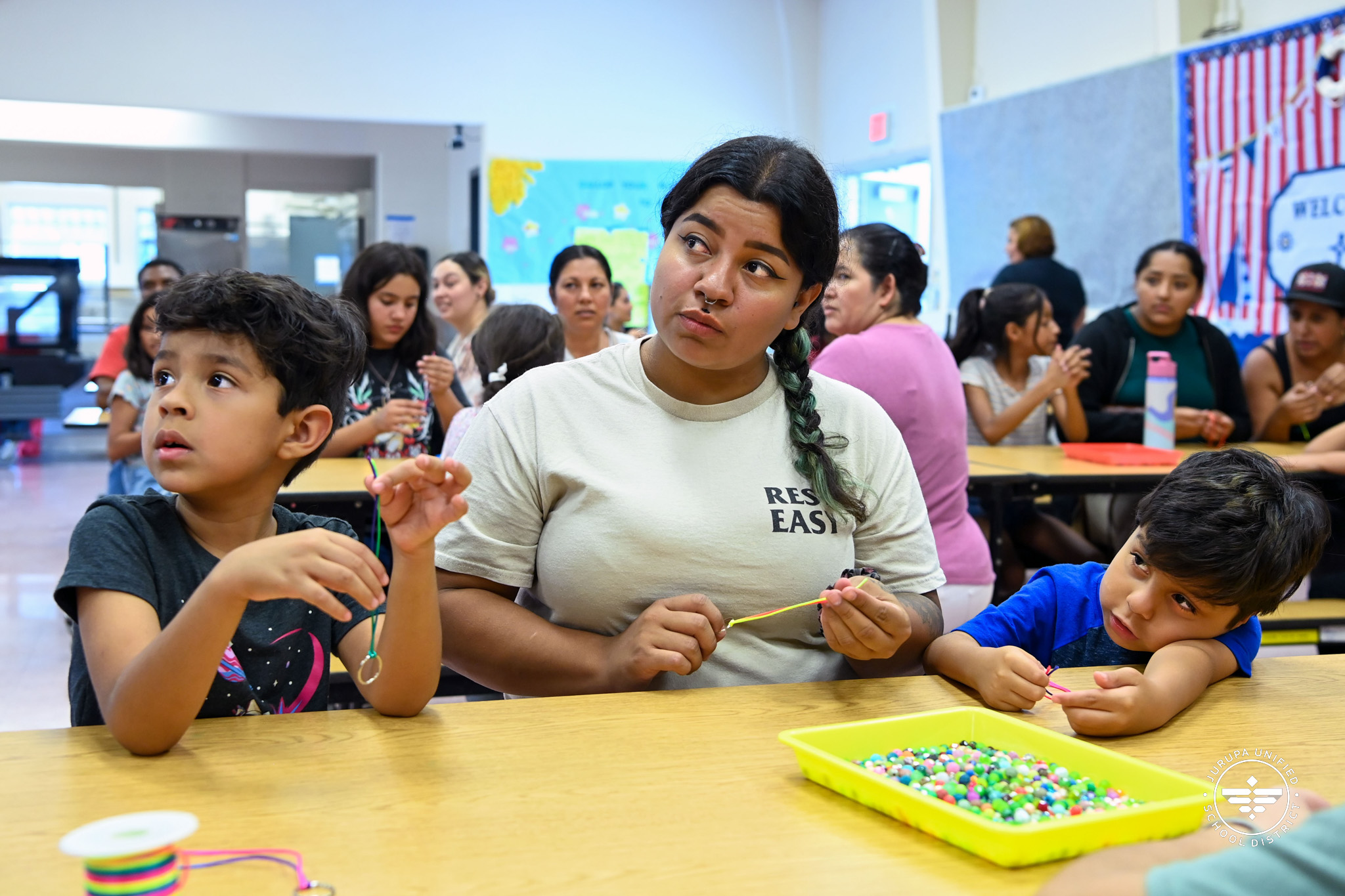 Tiffanie Carlos and her sons listen to instructions about the craft